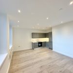 Modern empty kitchen with wooden flooring.