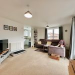 Spacious, modern living room with kitchen view.
