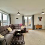 Cosy living room with corner sofa and balcony view