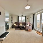 Bright living room with corner sofa and large windows.