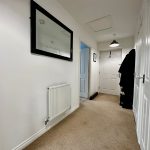 Bright hallway with carpet and mirror reflection