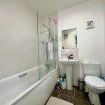Modern white bathroom with bathtub and sink.