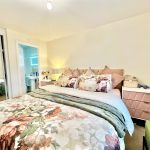 Cosy bedroom with floral bedding and ensuite bathroom.