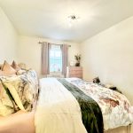 Cosy bedroom with floral bedding and natural light.
