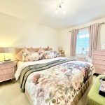 Cosy bedroom with floral decor and natural light.