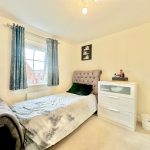 Bright bedroom with single bed, drawer, and window.