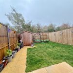Back garden with shed, swing, and plants