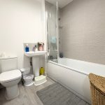 Modern bathroom with bathtub and wicker basket