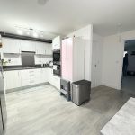 Modern kitchen with white cabinetry and stainless appliances.