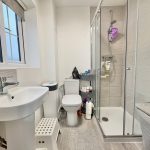 Modern bathroom with shower and sink.