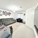 Spacious living room with sofas and piano.