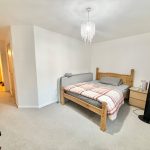 Cosy bedroom with wooden bed and chandelier