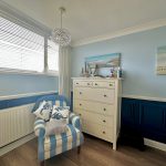 Coastal-themed bedroom with armchair and decorations.