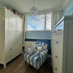 Cosy room with striped armchair and white furniture.