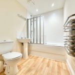 Modern bathroom with shower and towel rail.