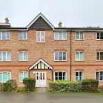Front view of red-brick apartment building.