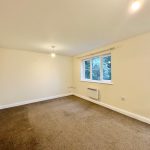 Empty room with carpet and window view.