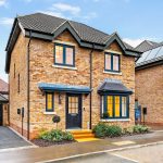 Modern red-brick house with garage and garden.