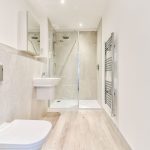 Modern bathroom with shower and towel rack.