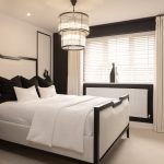 Modern monochrome bedroom with elegant decor and lighting.