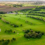Aerial view of golf course and countryside landscape.