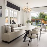 Modern dining area with garden view through open doors.