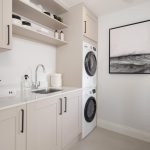 Modern laundry room with washer, dryer, and sink.