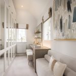 Elegant dressing room with mirrored wardrobes and paintings.