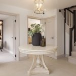 Elegant hallway with table and staircase.