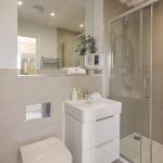 Modern bathroom with walk-in shower and basin.