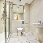 Modern bathroom with shower, toilet, and sink.