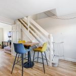 Cosy dining area by staircase in modern home.