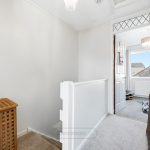 Bright upstairs hallway with open doorway and mirror