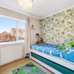 Child's room with forest-themed wallpaper and toys.