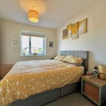Cosy bedroom with yellow accents and modern decor.