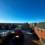 Urban street with brick houses and clear blue sky.