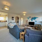 Modern living room with kitchen and world map decor.