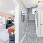 Modern living room with staircase and geometric tiles.