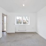 Empty room with white walls, door, and window.