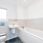 Minimalist white bathroom with bathtub and sink