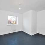 Empty white room with window and light fixture.