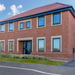 Modern brick house with double-storey windows.