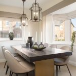 Modern dining room with wooden table and pendant lights.
