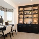 Modern home office with desk and shelves.