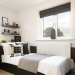 Modern bedroom with single bed and window view.