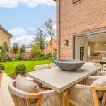 Modern patio with garden and open kitchen view.