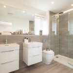 Modern bathroom with shower, sinks, and toilet