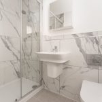 Modern marble bathroom with shower and sink.