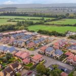 Aerial view of housing development and countryside fields.