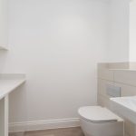 Minimalist modern bathroom with white and beige decor.